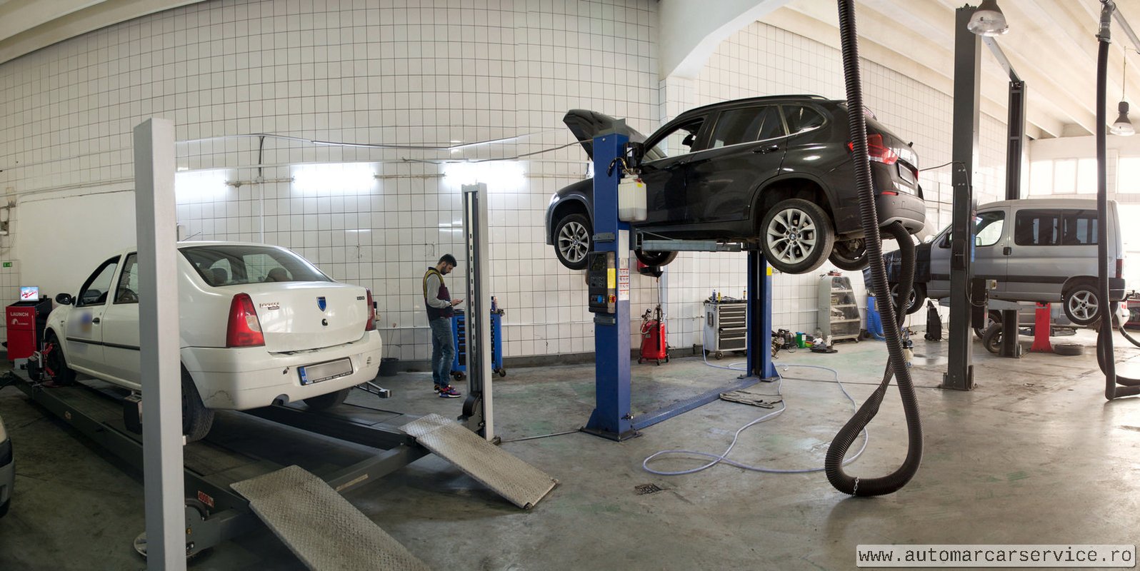 Panoramă atelier — multiple mașini pe elevatoare